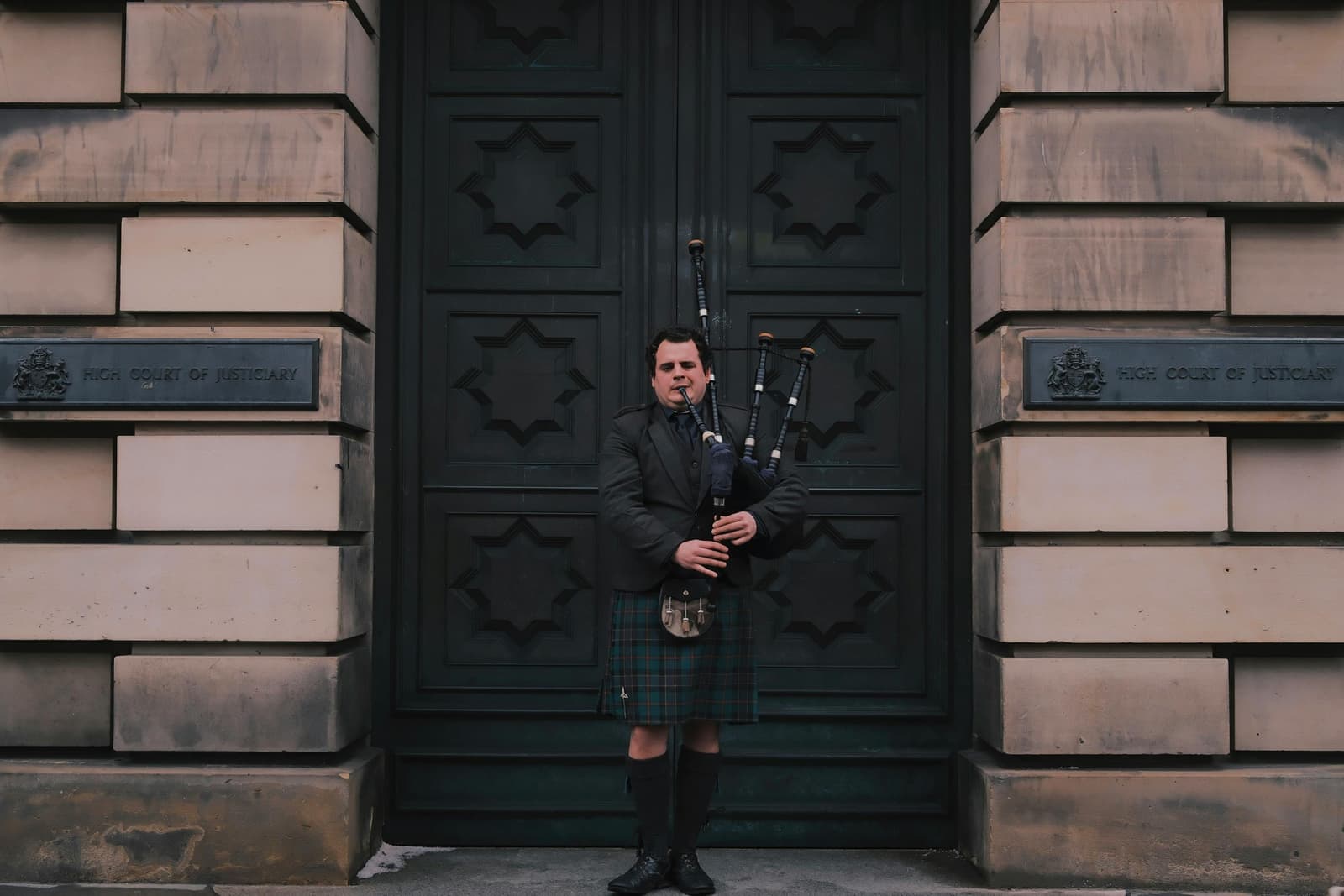 Scottish bagpiper outside the High Court of Justiciary - OrsiniAssets, Kirkcaldy Scotland